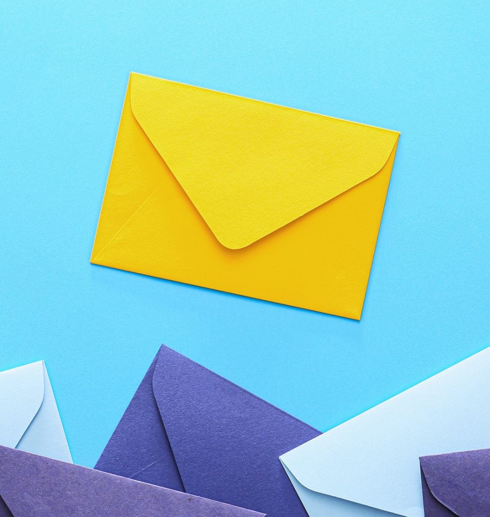 A yellow envelope sits above a scattered pile of lilac and purple envelopes against a bright blue background.