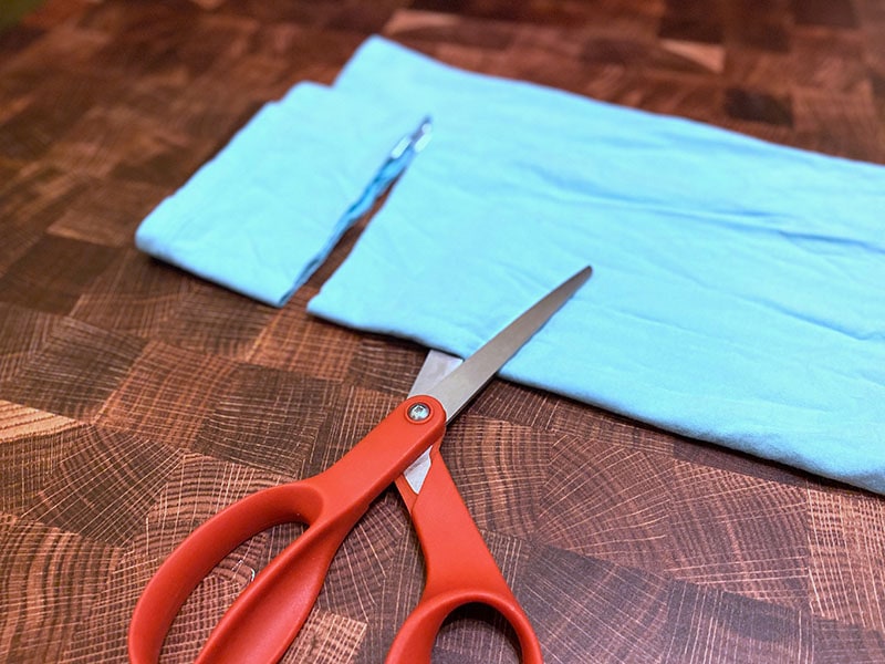 Fabric is folded and one 3" strip is cut with the scissors placed 3" away for the next cut