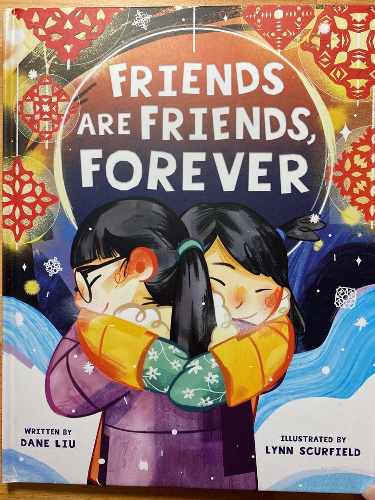 A kids book called "Friends are friends forever" shows two kids hugging in a snowy setting