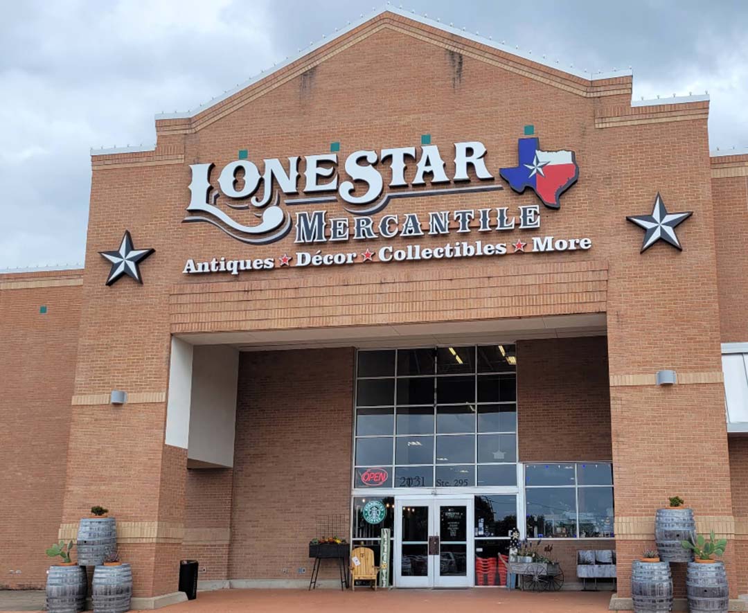 A tall brown brick building with a white sign that reads "Lone Star Mercantile"